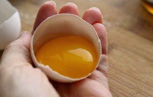 Mezzo uovo tenuto in mano