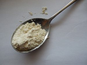 Cucchiaio colmo di proteine whey del siero di latte